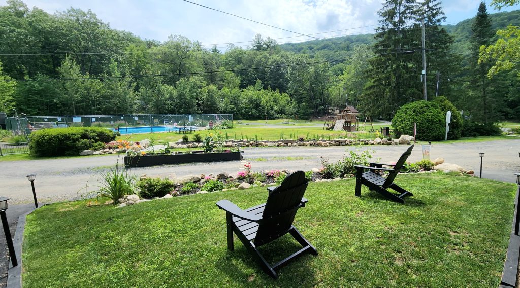 lounge chairs overlooking woodsy campground and pool